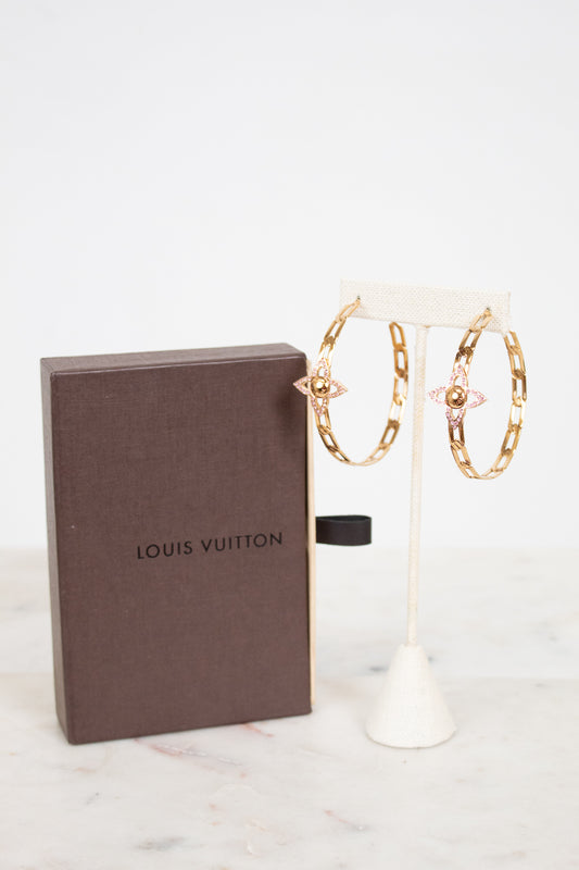 Louis Vuitton jewelry box with gold hoop earrings with pink accents on a stand