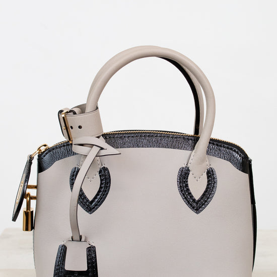 White handbag with black accents on a light background
