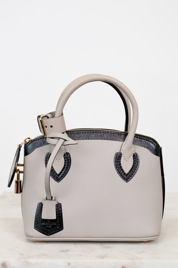 White handbag with black accents on a light background