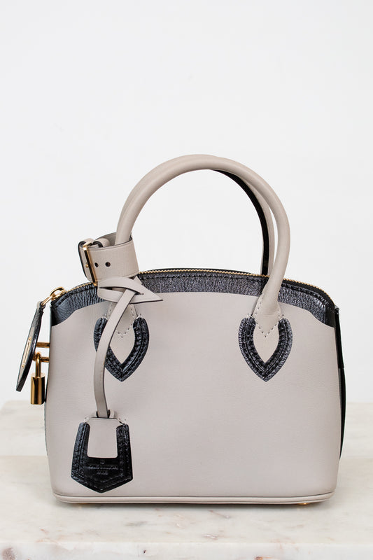 White handbag with black accents on a light background