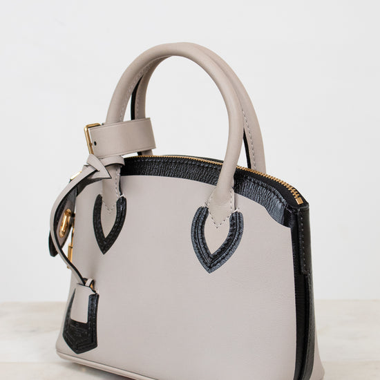 White handbag with black accents on a white background