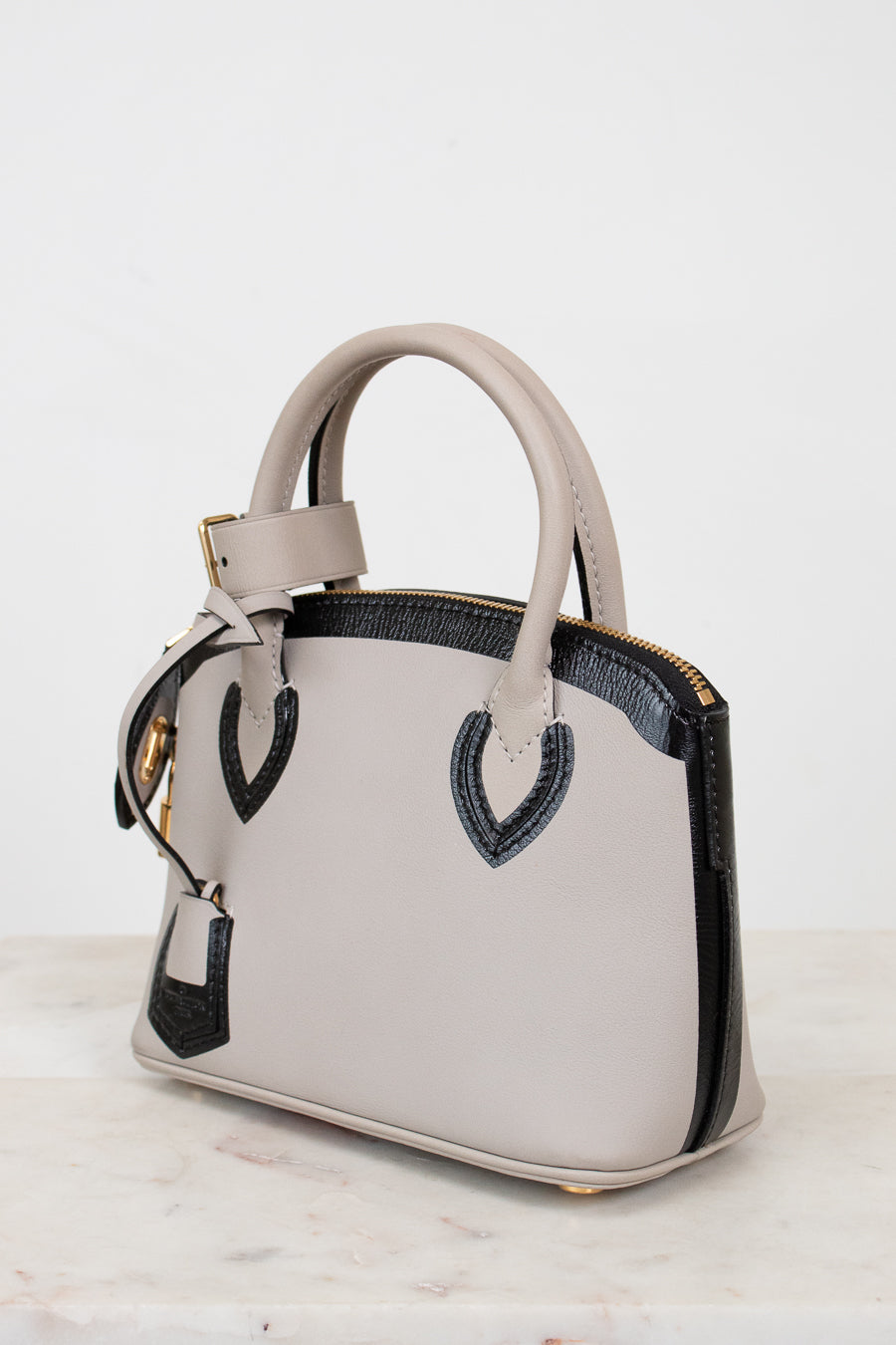 White handbag with black accents on a white background