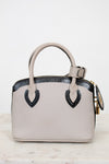 White handbag with black accents on a marble surface