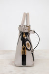Silver handbag with black strap and gold lock on a white background