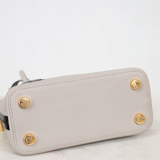 Light gray wallet with gold accents on a marble surface