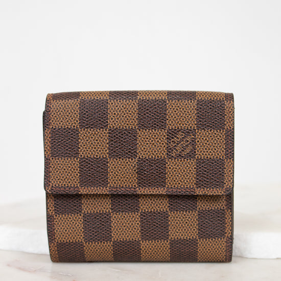 Brown checkered wallet on a white surface