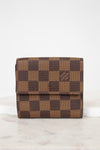 Brown checkered wallet on a white surface