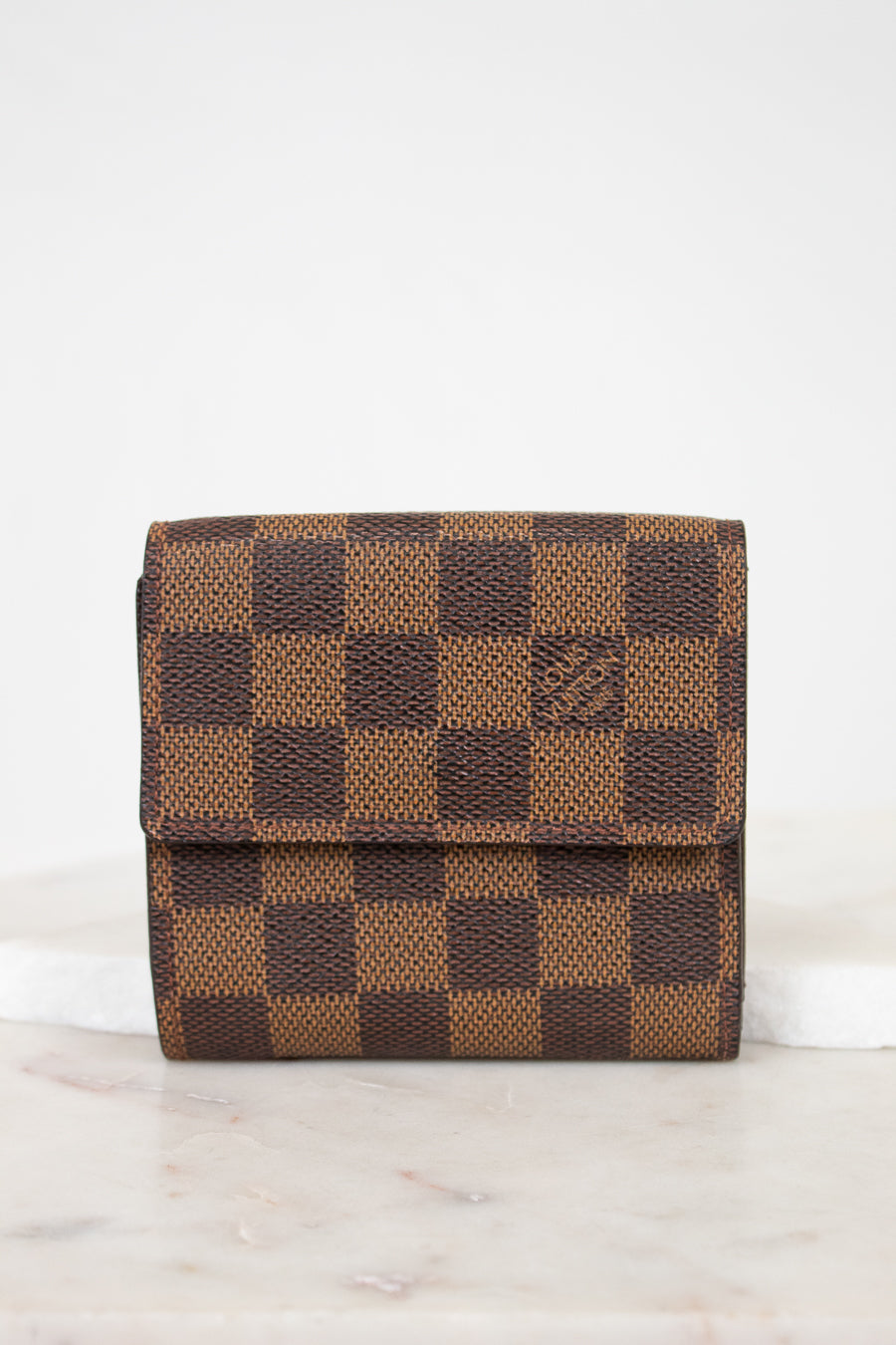 Brown checkered wallet on a white surface