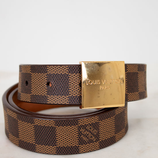 Louis Vuitton belt with gold buckle on a light background