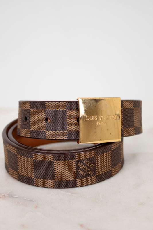 Louis Vuitton belt with gold buckle on a light background