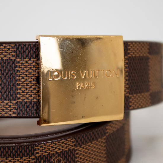 Louis Vuitton belt with gold buckle on a light gray background