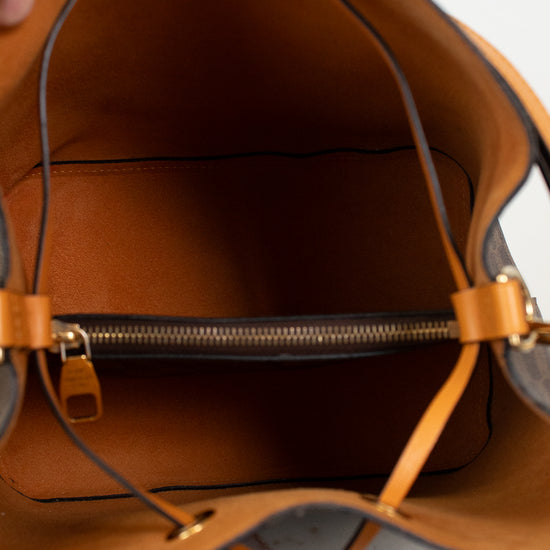 Close-up of a brown interior of handbag with gold zipper hardware.