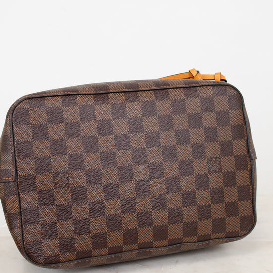 Bottom view of brown checkered tote bag on a white marble surface