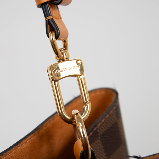 Close-up of a gold clasp on a light gray background
