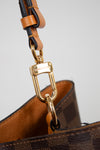 Close-up of a gold clasp on a light gray background