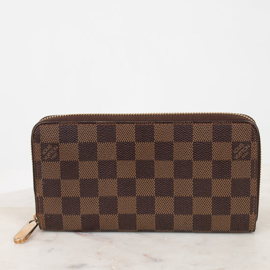 Brown checkered wallet on a marble surface