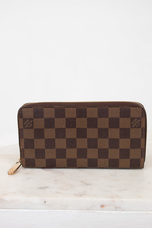 Brown checkered wallet on a marble surface