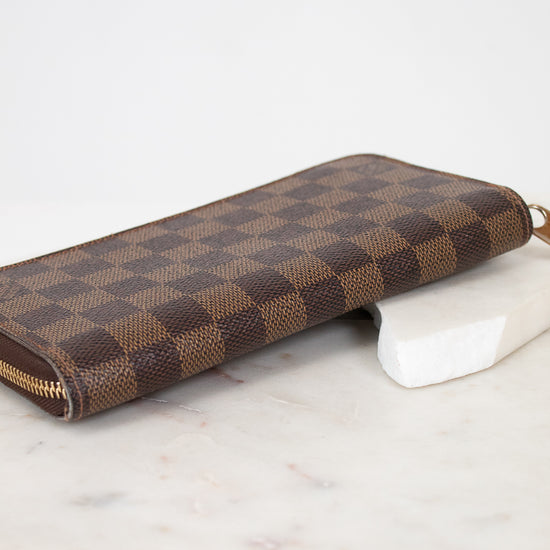 Brown checkered wallet on a marble surface