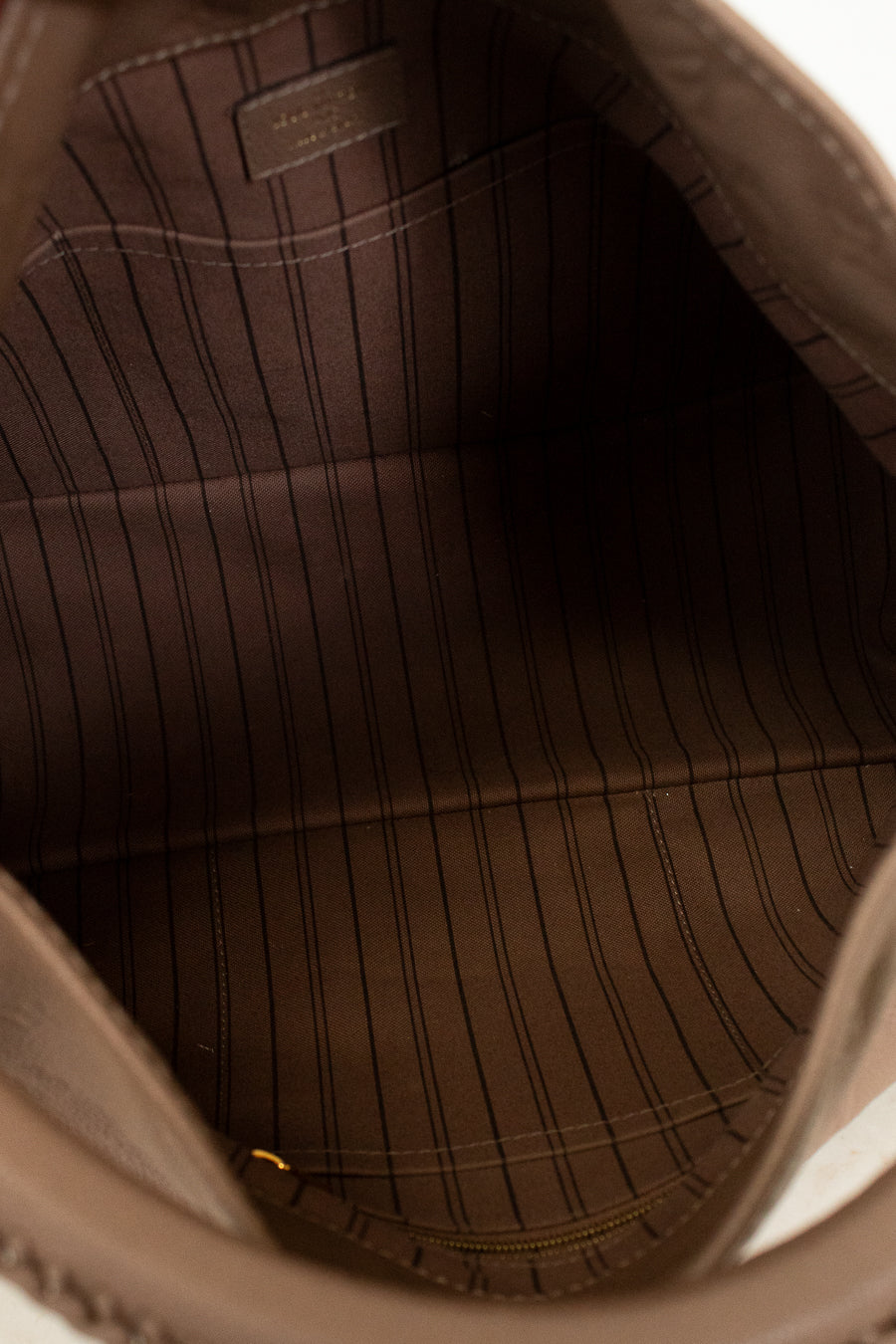 Close-up of a beige leather bag with visible stitching