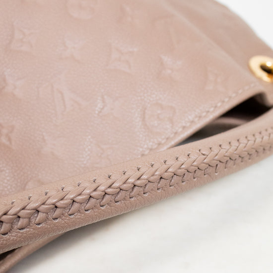 Close-up of a beige leather purse with braided edge on a white background