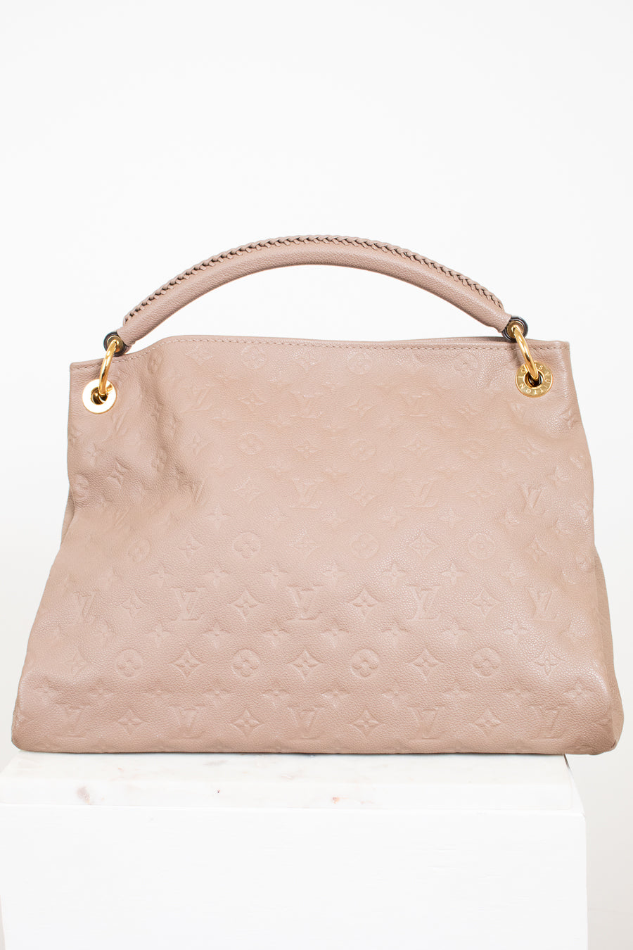 Taupe handbag with gold accents on a white background