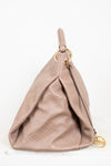 Beige handbag with gold hardware on a white background