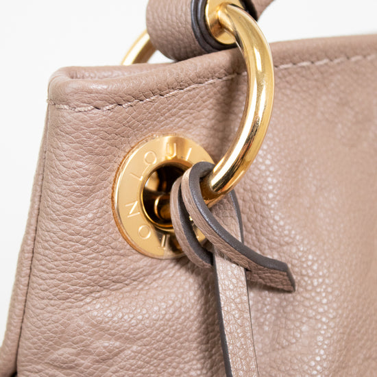 Close-up of a beige leather handbag with a gold clasp on a white background