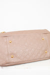 Beige handbag with gold hardware on a white background