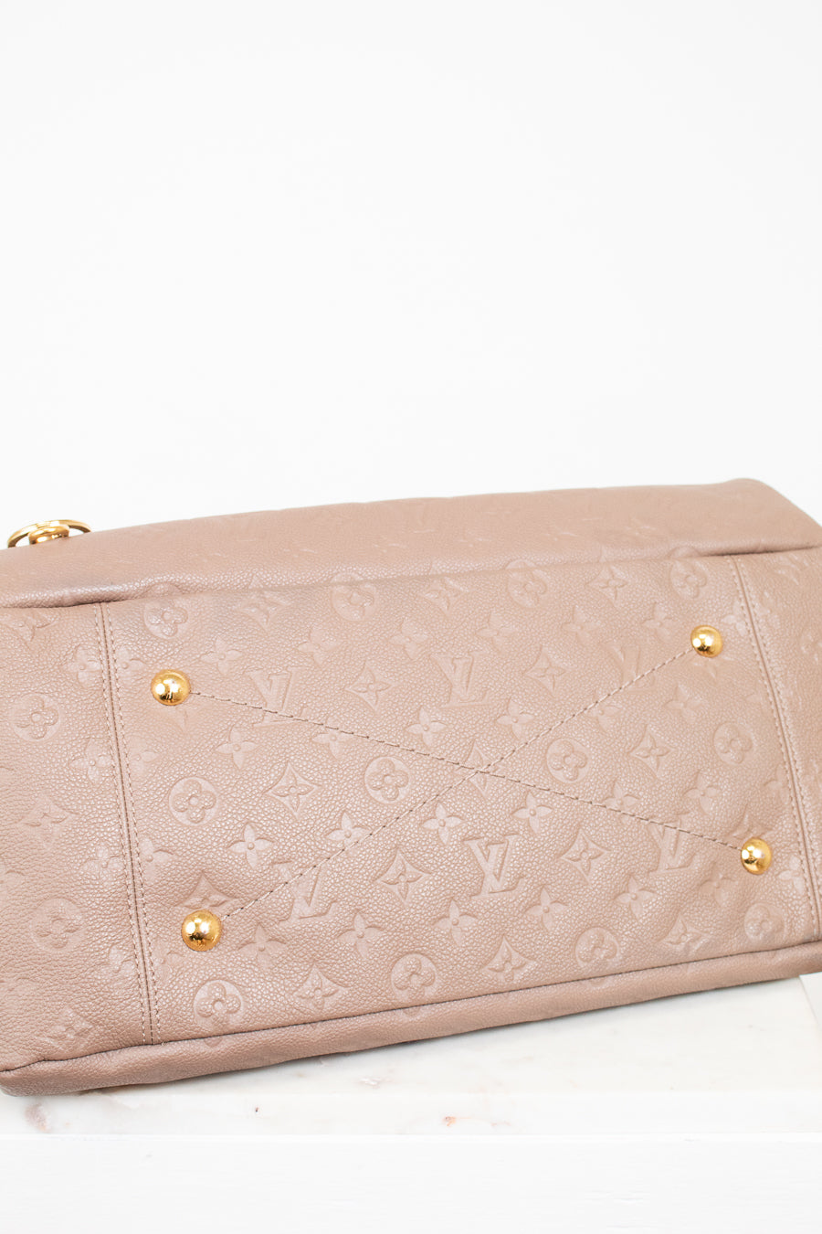 Beige handbag with gold hardware on a white background