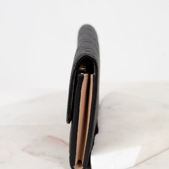 Black wallet on a white marble surface