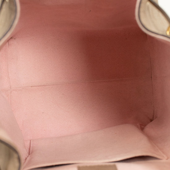 Close-up of a pink interior of handbag with visible stitching and a brand label.