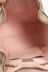 Close-up of a pink interior of handbag with visible stitching and a brand label.