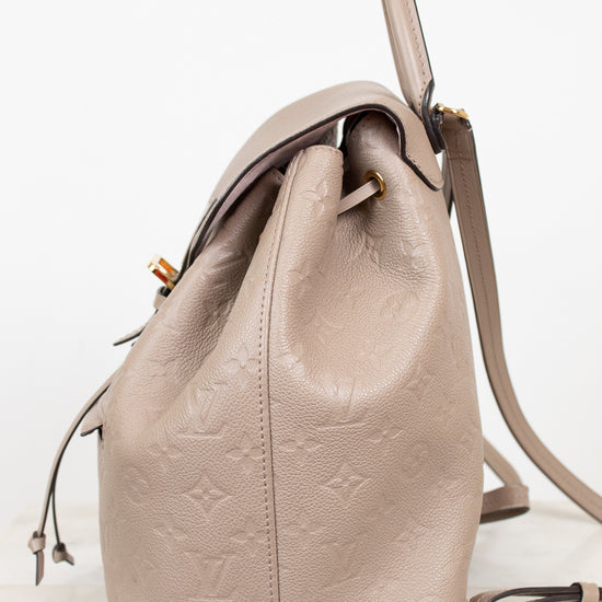 Beige leather backpack with monogram pattern on a white background