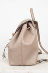 Beige leather backpack with monogram pattern on a white background