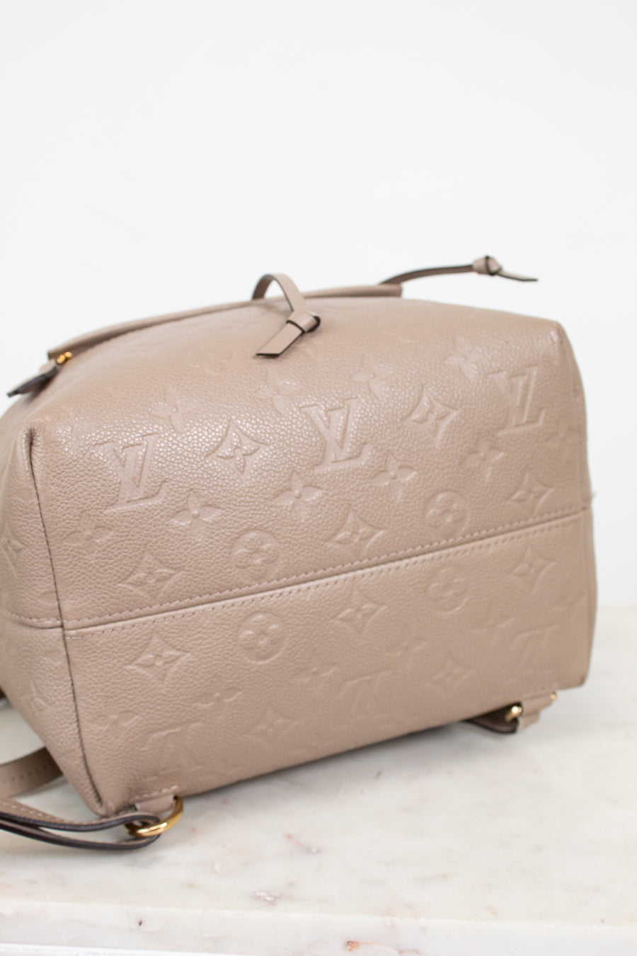 Beige handbag with monogram pattern on a white background