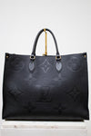 Black embossed handbag with gold accents on a white background