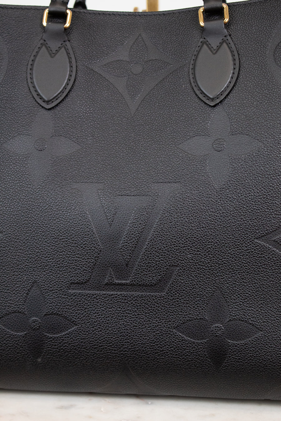 Black handbag with brand logo on a light background