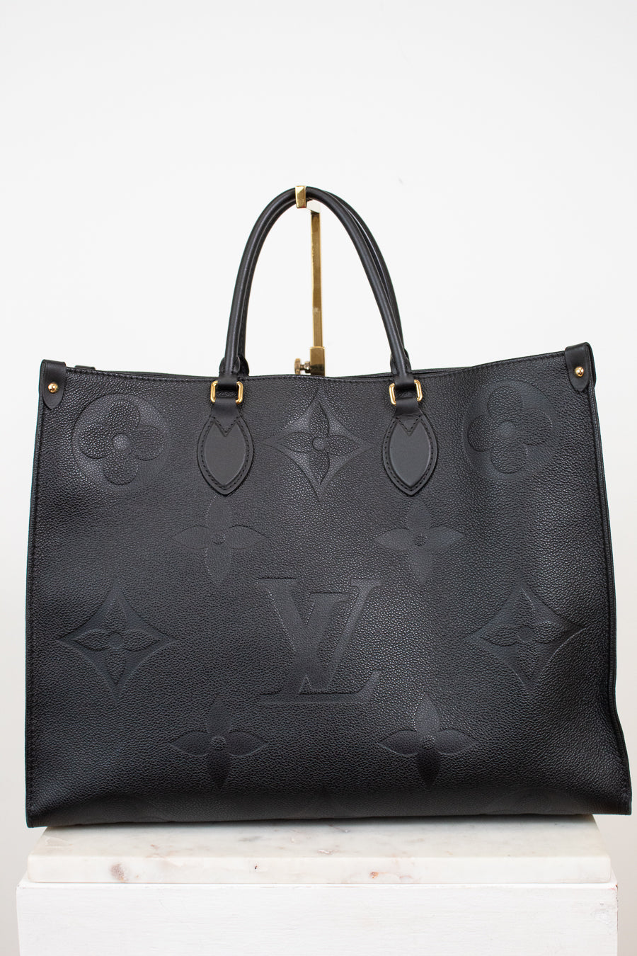 Black handbag with gold hardware on a white background