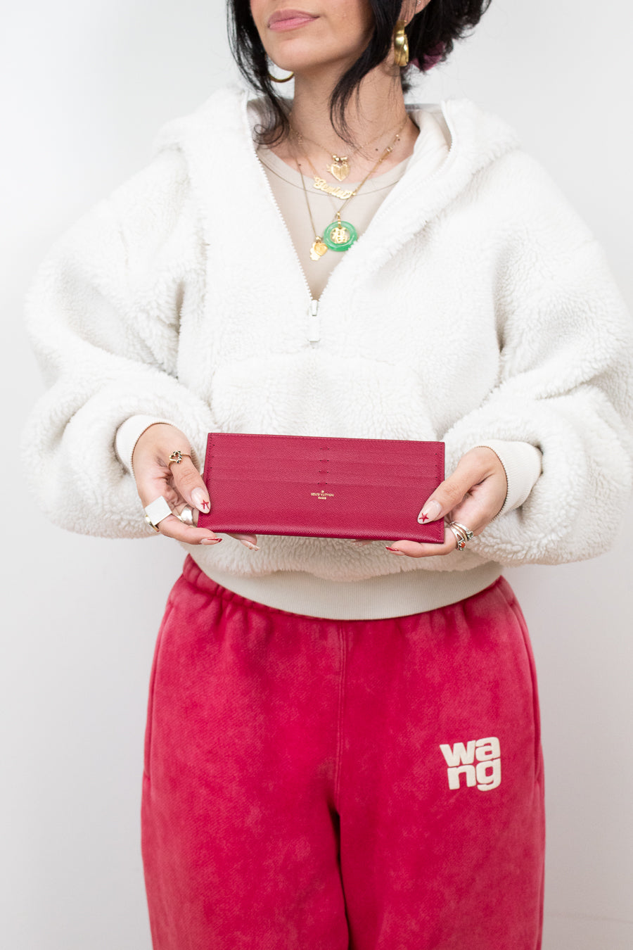 Person holding a red wallet with a plain background