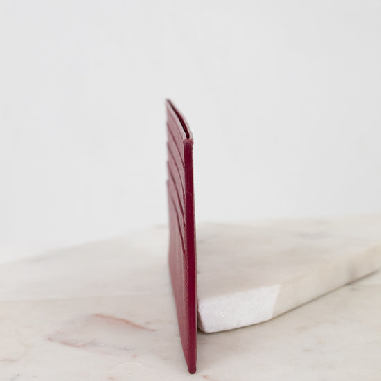 Red wallet on a marble surface with a white background