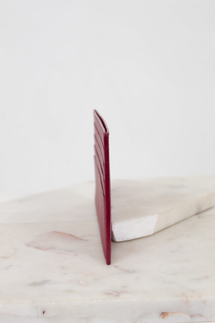 Red wallet on a marble surface with a white background
