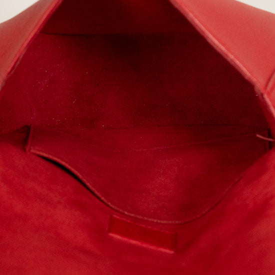 Close-up of a red bag with a hand opening it.