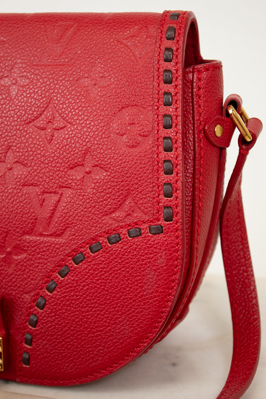 Red handbag with brand logo on a light background