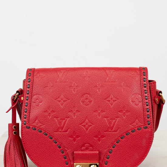Red handbag with gold accents on a light gray background