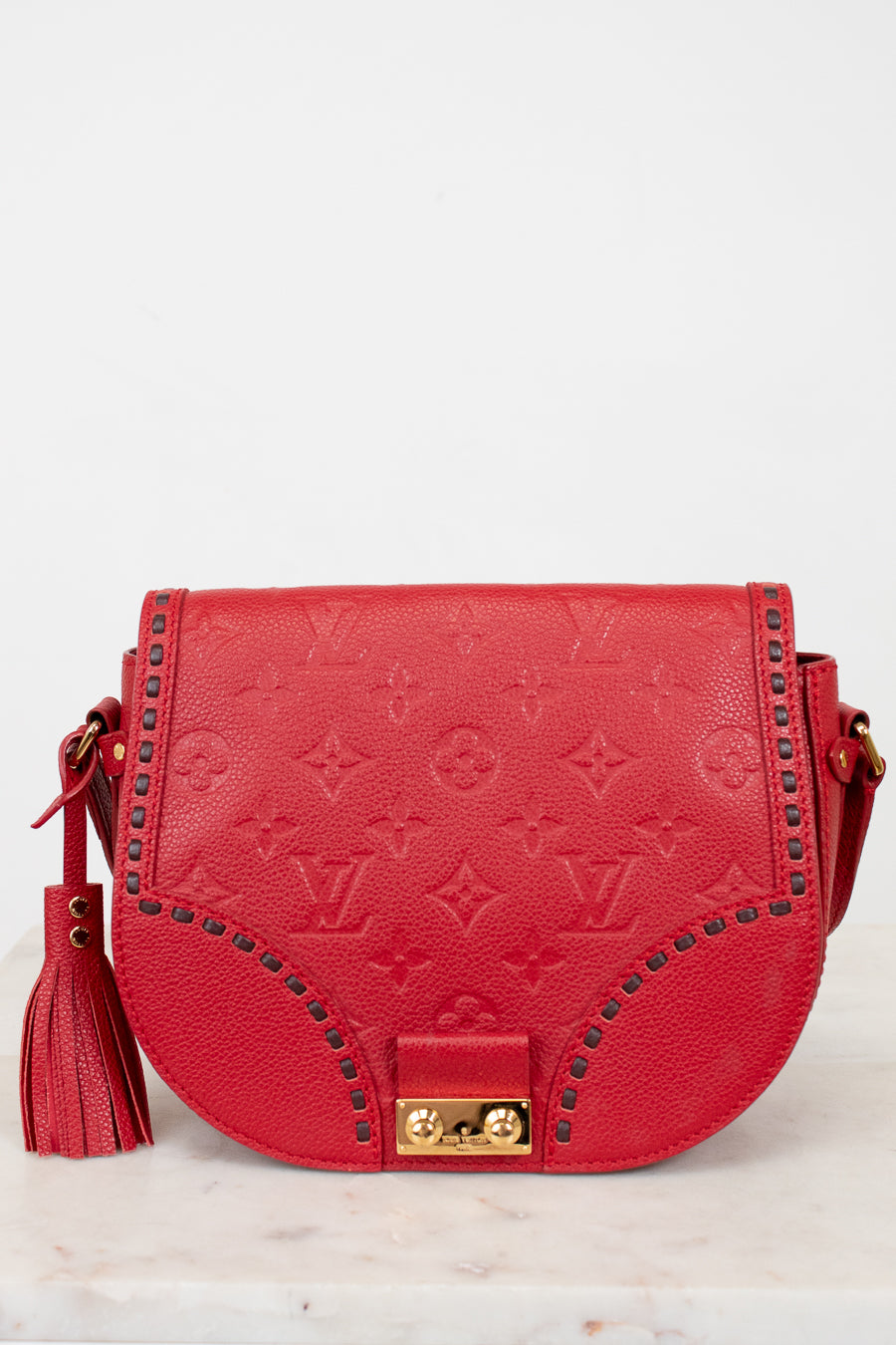 Red handbag with gold accents on a light gray background