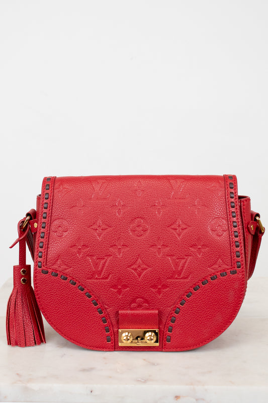 Red handbag with gold accents on a light gray background