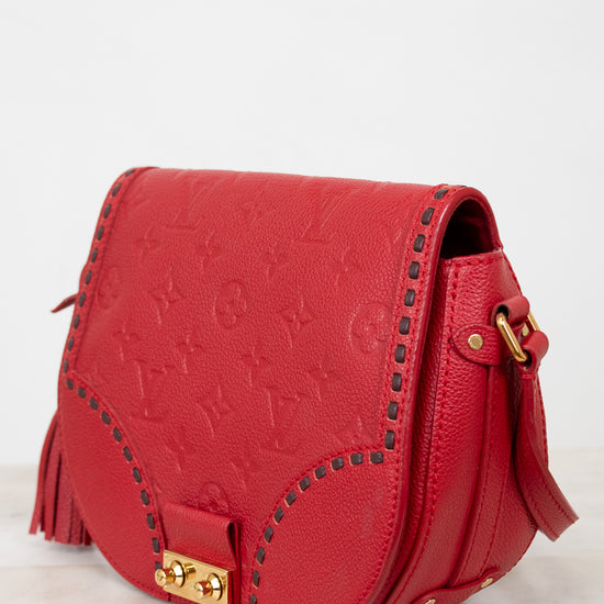 Red handbag with gold accents on a light gray background