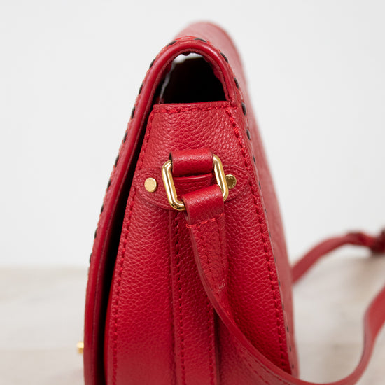 Red handbag with gold accents on a light background