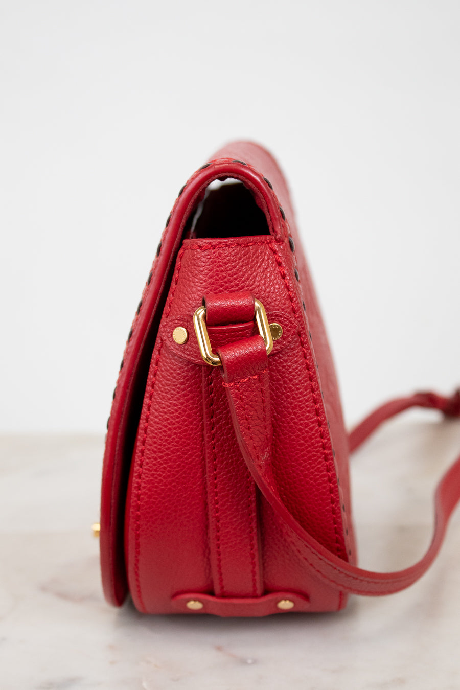 Red handbag with gold accents on a light background