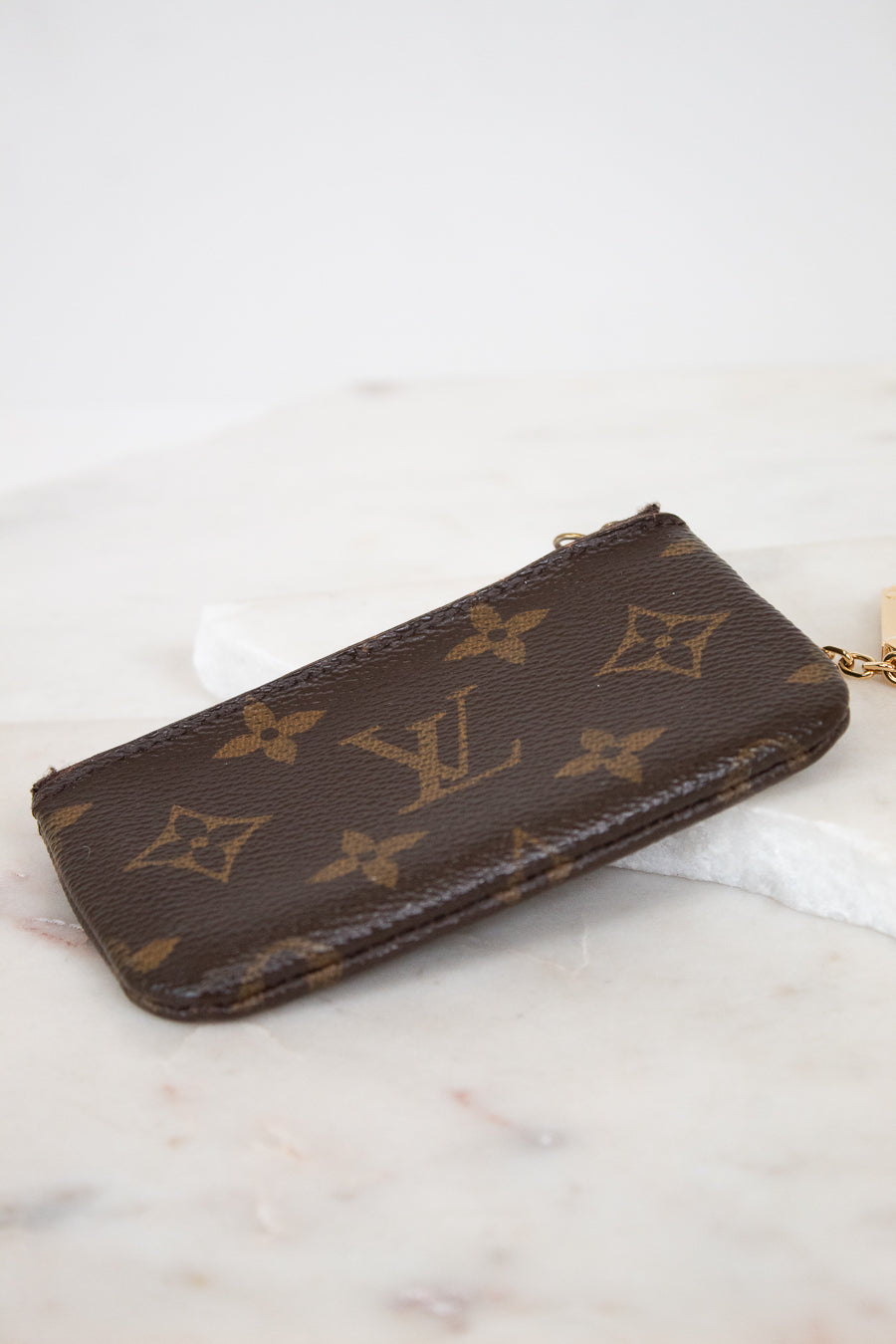 Louis Vuitton wallet with monogram pattern on a marble surface
